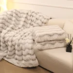 Plush white faux fur blankets on beige sofa