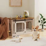 Corgi sitting near indoor wooden dog crate
