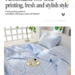 Two-tone light blue floral bedding on bed