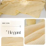 Pale yellow quilted bedspread on white bed