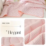 Soft pink quilted bedspread with pillows